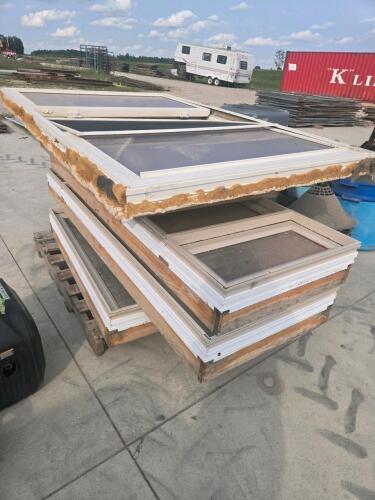 Pile of various sized used vinyl opening windows